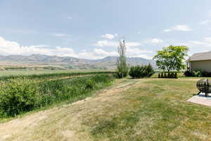 View of grassy yard featuring a mountain view and a rural view