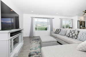 Living area with light wood finished floors, a ceiling fan, and recessed lighting