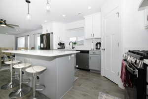 Kitchen with stainless steel appliances, plenty of natural light, a kitchen breakfast bar, a kitchen island, and recessed lighting
