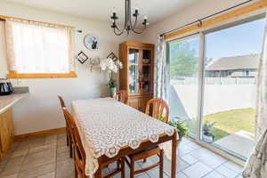 Dining area featuring baseboards and a chandelier