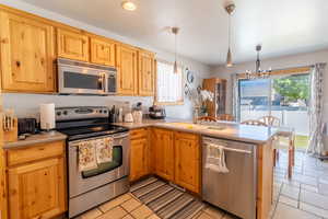 Kitchen with stainless steel appliances, plenty of natural light, light countertops, and recessed lighting