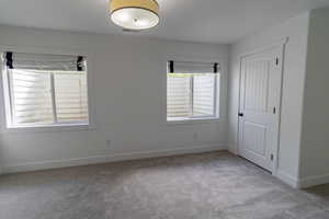Unfurnished bedroom featuring light colored carpet and a closet