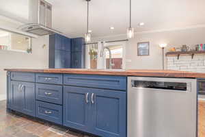 Kitchen with wooden counters, stainless steel dishwasher, blue cabinetry, island range hood, and ornamental molding