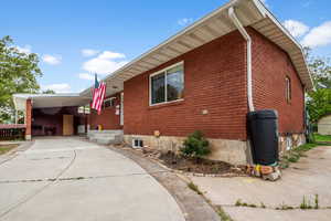 View of home's exterior featuring concrete driveway and an attached carport