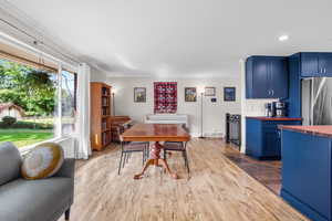 Dining space featuring ornamental molding, light wood-style floors, and recessed lighting