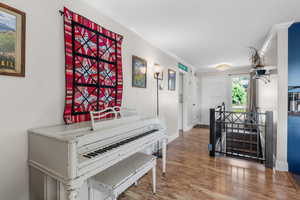 Hallway featuring wood finished floors and crown molding