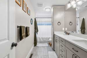 Full bath with double vanity and shower / tub combo with curtain