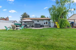 Rear view of property with a gazebo, entry steps, a chimney, and a patio area
