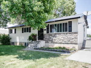 Ranch-style house featuring a front lawn and stone siding