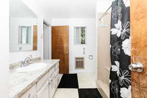 Full bath featuring heating unit, vanity, and a shower with curtain