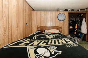 Bedroom featuring wooden walls