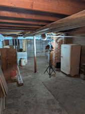 Unfinished basement with fridge