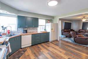Kitchen with white appliances, open floor plan, healthy amount of natural light, and backsplash