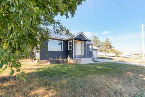 View of front of house with a front yard, a metal roof, and an attached garage
