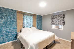 Carpeted bedroom with ornamental molding and cooling unit