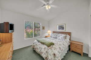 Bedroom featuring carpet, vaulted ceiling, and ceiling fan