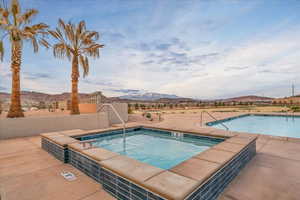 Community pool featuring a hot tub, a mountain view, and a patio area