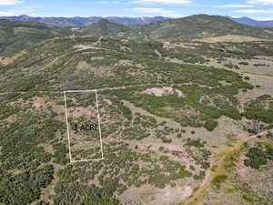Aerial overview of property's location featuring property parcel outlined and a mountain backdrop