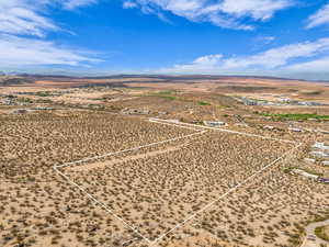 Aerial view of sparsely populated area with mountains and a desert landscape. Looking West