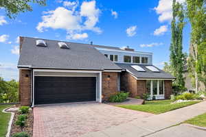Mid-century home with brick siding, decorative driveway