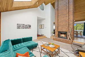 Living area featuring beautiful vaulted wood ceilings, brick fireplace, open to dining area