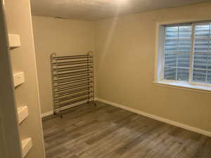 Empty room featuring wood finished floors and a textured ceiling