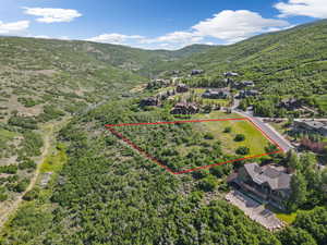 Aerial view of property's location with a mountainous background and property parcel outlined