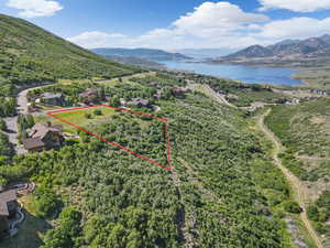 Aerial view of property and surrounding area featuring a water and mountain view and property boundaries highlighted