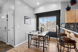 Dining room featuring vaulted ceiling, wood finished floors, and recessed lighting