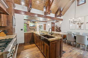 Kitchen with stainless steel appliances, wooden ceiling, light wood finished floors, open floor plan, and ceiling fan