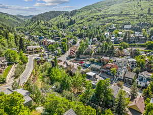 Aerial perspective of suburban area with a mountainous background and a forest