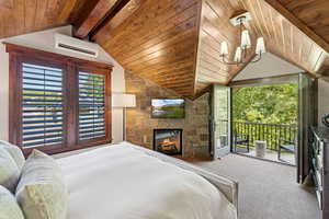 Bedroom featuring a wall mounted AC, access to outside, carpet flooring, a fireplace, and wood ceiling