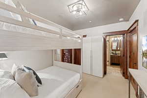 Bedroom featuring light carpet and a sink