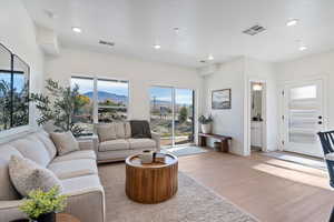 Living room featuring a mountain view, light wood finished floors, and recessed lighting