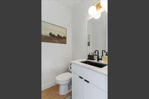 Half bathroom featuring vanity and light wood-style flooring