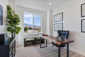 Office with light carpet, a mountain view, and recessed lighting