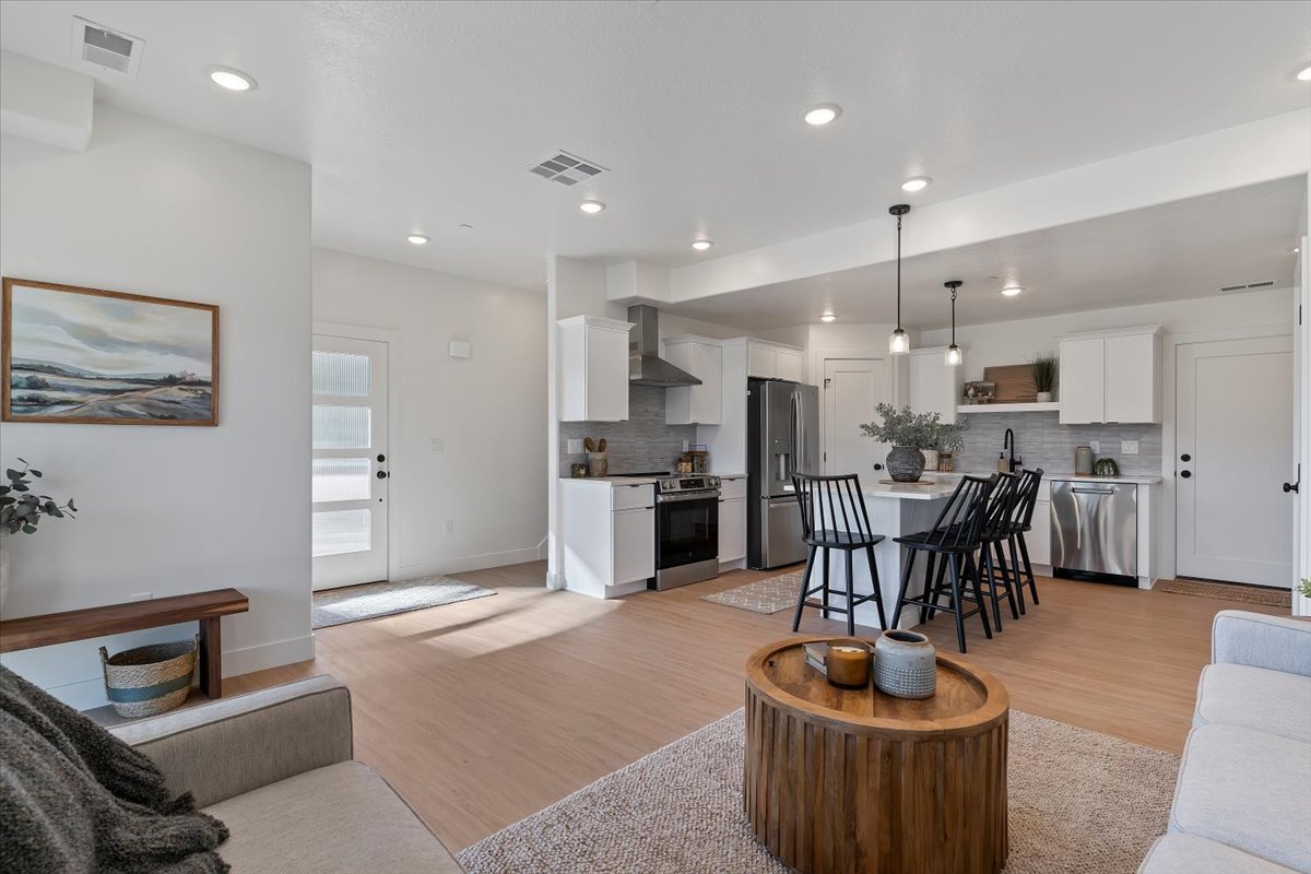 Living area with light wood finished floors and recessed lighting