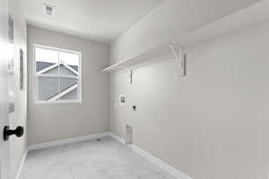 Laundry room with electric dryer hookup, hookup for a washing machine, and light marble finish flooring