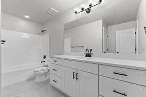 Full bath with vanity,  shower combination, marble finish flooring, and recessed lighting