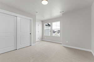 Unfurnished bedroom with carpet flooring and a closet