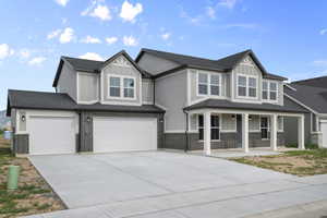 View of front of home featuring covered porch, board and batten siding, an attached garage, driveway, and a shingled roof