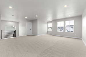 Unfurnished living room featuring light carpet and recessed lighting