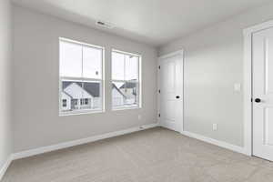 Unfurnished bedroom featuring light colored carpet