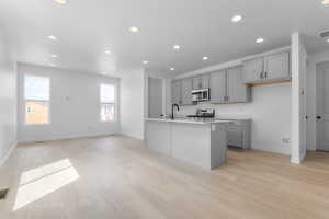 Kitchen featuring appliances with stainless steel finishes, gray cabinetry, recessed lighting, and light wood-type flooring