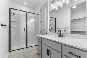 Full bathroom featuring a stall shower, vanity, recessed lighting, a walk in closet, and tile patterned floors