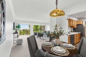 Dining area featuring carpet floors, ornamental molding, and a textured ceiling