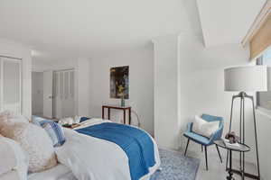 Carpeted bedroom with crown molding and multiple closets