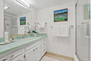 Full bathroom featuring vanity, a tile shower, and tile patterned floors