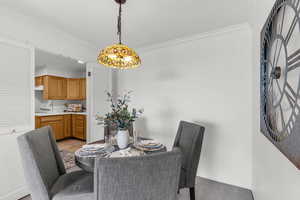 Dining space with crown molding and a chandelier
