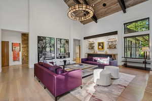 Living area featuring high vaulted ceiling, wood finished floors, and a wood ceiling with exposed beams